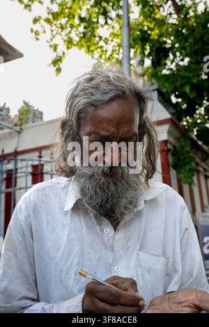 Chennai, Indien – 2. August 2026: Älterer indischer Mann mit langem grauem Bart, der nach unten schaut und einen Stift hält Stockfoto