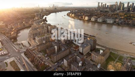 Sonnenuntergang über der Themse, zeigt das Wohnviertel von Deptford mit Blick auf die Wolkenkratzer von Canary Wharf und Isle of Dogs. Stockfoto