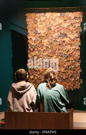 Besucher erleben eine immersive Audioinstallation mit einer Blattwandanzeige in der Wellcome Collection in London. Stockfoto