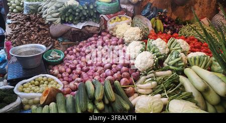 Reiche Vielfalt an frischem Gemüse und roten Zwiebeln, die auf einem traditionellen Markt angeboten werden. Stockfoto