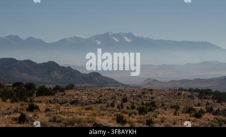 Neblige schneebedeckte Berge in der Nähe von Vernon, Utah. Schichten von nebligen Vorgebirgen führen zu schneebedeckten Gipfeln nahe Vernon, Utah. Stockfoto