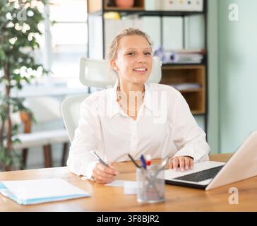 Junge Frau am Laptop im Büro arbeiten Stockfoto