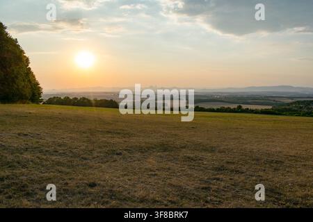 Sonnenuntergang über sanften Feldern in der Nähe von Prag mit einem fernen Heißluftballon Stockfoto