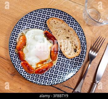 Frühstück mit gegrillten Chorizo-Würstchen, Spiegelei und Brot Stockfoto