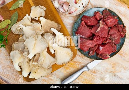 Rohe Kalbfleischstücke, Gewürze und Austernpilze. Stockfoto
