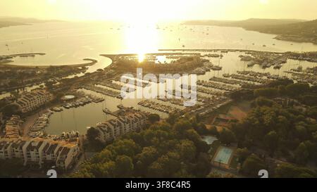Warmes Sonnenlicht über einem mit Booten gefüllten Yachthafen, gesehen von oben. Cogolin, Frankreich Stockfoto