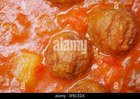 Fleischbällchen in einer reichhaltigen Tomatensoße mit Gemüse kochen Stockfoto