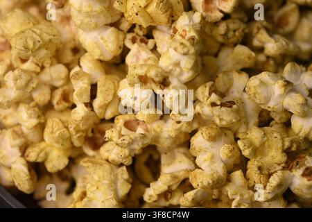 Golden-Popcorn-Makro-Muster, das herzhafte knusprige Snack-Details zur Schau stellt Stockfoto