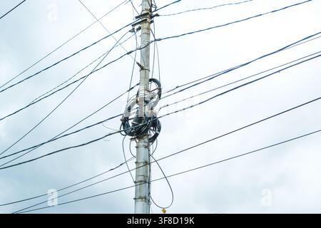Rjasan, Russland, 28.09.2025 Strommast mit vielen Stromleitungen und Kommunikationskabeln vor einem leicht bewölkten Himmel. Komplexes Netzwerk für Strom und Stockfoto