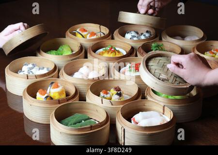 Verschiedene gedämpfte chinesische Dim Sum in Bambuskörben. Stockfoto