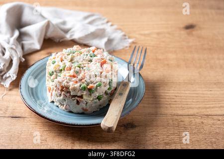 Traditioneller russischer Salat mit Thunfisch und Gemüse auf Holztablett Stockfoto
