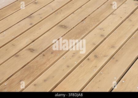 Hochwinkelperspektivansicht von Holzterrassenbelägen als Hintergrund. Natürliche Holzplankenoberflächentextur mit Schrauben, geeignet für Außenterrassen Stockfoto