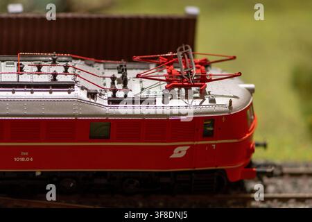 WIEN, ÖSTERREICH, 26. November 2022: Eine Nahaufnahme zeigt eine rote OBB 1018.04 Elektromodell-Lokomotive mit detailliertem Dachstromabnehmer auf den Gleisen. Stockfoto