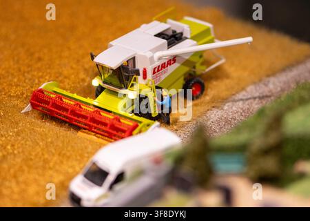 WIEN, ÖSTERREICH, 26. November 2022 : Ein Miniaturmodell einer Claas-Mähdrescher mit einer kleinen Arbeiterfigur steht in einem Weizenfeld-Diorama in der Nähe eines verschwommenen Stockfoto