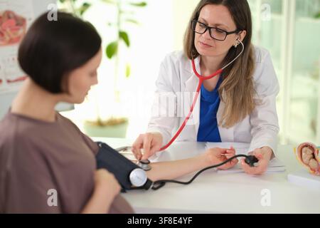 Ärztin überprüft den Blutdruck bei einer schwangeren Patientin Stockfoto