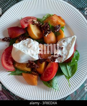 Flat Lay eines Gourmet-Frischsalats aus Oregon-Pfirsichen und Basilikum mit Burrata-Käse und kandierten Walnuss-Toppings, 2026, USA Stockfoto