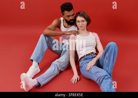 Ein liebevolles multikulturelles Paar posiert zusammen und genießt einen zärtlichen Moment vor einem lebendigen Hintergrund. Stockfoto