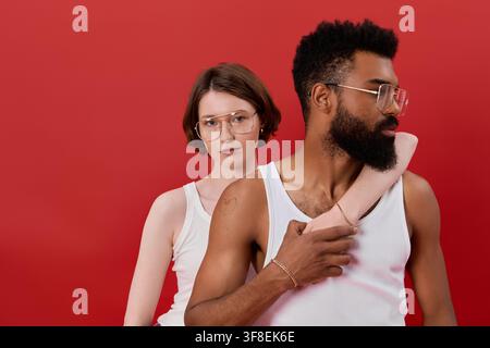 Ein stilvolles multikulturelles Paar teilt einen freudigen Moment vor einem lebendigen Hintergrund. Stockfoto