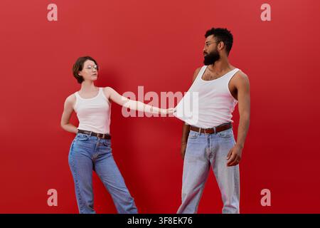Ein glückliches multikulturelles Paar teilt einen wunderschönen Moment, gekleidet in schicken Stilen und posiert verspielt. Stockfoto