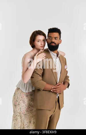 Ein fröhliches multikulturelles Paar teilt eine süße Umarmung, gekleidet in schicker Kleidung und strahlender Liebe. Stockfoto