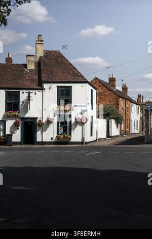 Ansicht eines historischen weißen Gebäudes mit grünen Fensterrahmen und Blumenkästen in der St. Mary's Street, mit einem Geschwindigkeitsschild und Backsteingebäuden in Glouc Stockfoto