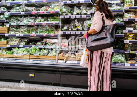 London UK, 12. August 2026, Abgeschnittener Blick auf eine nicht erkennbare Frau, die einen Drahtkorb hält und frisches Gemüse in Marks And Spencer durchsieht Stockfoto