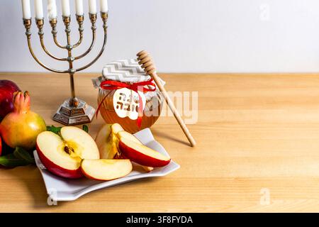 Feiertagsymbole für das jüdische Neujahr, darunter Äpfel, Honig, Granatäpfel und ein Kandelaber Stockfoto