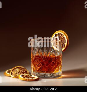 Erfrischender Rum-Cocktail, garniert mit getrockneten Orangenscheiben in einem Kristallglas. Kopierraum. Stockfoto