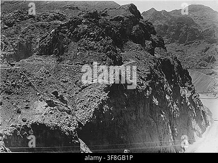 Eine Fotografie von 1932 der Arizona-Aufnahmetürme, wie sie von der Nevada-Seite stromaufwärts von der Nevada-Überlaufstelle aus gesehen werden, während des Baus des Hoover-Damms, mit Triangulationspunkt P-17 an der Spitze einer fast senkrechten Schluchtwand im Zentrum, Boulder City, Nevada. Stockfoto