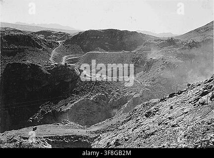 Eine Fotografie von 1932 des Arizona-Spillway-Beckens am Hoover-Damm, aufgenommen vom hohen Seilbahnsteig auf der Nevada-Seite, zeigt den Aushub für die Arizona-Spillway-Einlasstürme am Rand des Canyons, mit dem Seilbahnsteig auf einer Höhe von 1360 über dem Arizona-Spillway-Aushub. Stockfoto