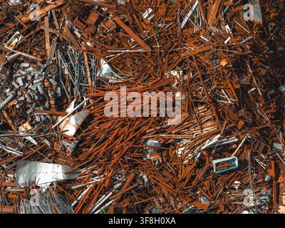 Luftaufnahme von rostigem Stahlschrott, Metallträgern und Industrierestmassen, die auf einem Metallrecyclinghof in Polen aufgeschichtet sind. Stockfoto