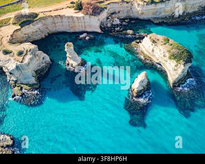 Luftaufnahme von Strand Torre Sant'Andrea mit Kalkstein-Kliffen, die aus türkisfarbenem Wasser aufragen, umgeben von schroffen Klippen und Küstenpfaden in Melend Stockfoto