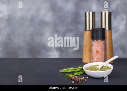 Getrocknetes Rosmarin-Gewürz mit frischen Kräutern, Salz- und Pfefferstreuern Stockfoto