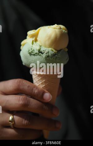 Person hält eine Eiswaffel mit zwei Kugeln in der Hand Stockfoto