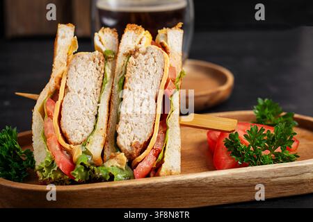 Frisches Hühnchen-Club-Sandwich auf dunklem Hintergrund serviert Stockfoto