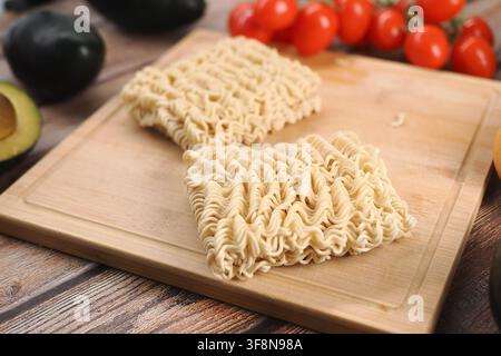 Nudeln, die auf einem Holzschneidebrett in einer Küche platziert sind Stockfoto
