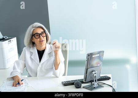Erfahrener Arzt berät einen Patienten unter Verwendung eines Tablets für Telemedizin Stockfoto