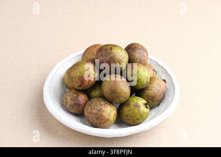 Frische Matoa-Frucht auf weißem Teller serviert Stockfoto