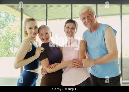 Porträt einer vielfältigen kaukasischen Gruppe von Senioren und jungen Menschen, die nach dem Fitness-Training lächeln. Das Bild repräsentiert einen aktiven Lebensstil und eignet sich für das Gesundheitsmarketing Stockfoto