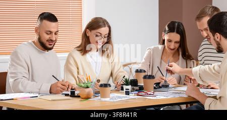 Gruppe junger Erwachsener lernt Kalligraphie und Zeichnen in einer kreativen Workshop-Atmosphäre, konzentriert auf künstlerischen Ausdruck und Fähigkeitenentwicklung Stockfoto