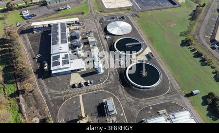 Wassereinigungsanlage mit großen runden Becken und Reihen von Solarpanelen, die nachhaltige Energie und Umweltschutz demonstrieren Stockfoto