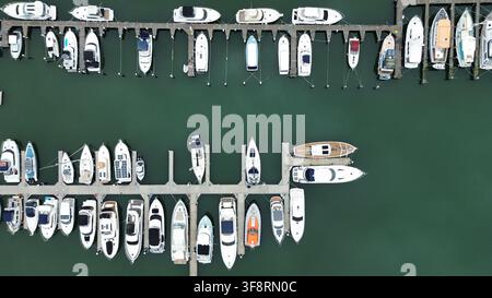 Boote und Yachten, die in einer belebten Marina vertäut sind, gesehen aus einer Luftansicht von oben, repräsentierend maritime Freizeit und Transport Stockfoto