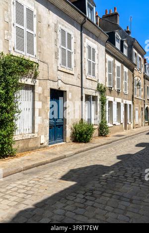 Eine ruhige Wohnstraße in Orléans, Frankreich, gesäumt von Kalksteinfassaden, geschlossenen Häusern und Kopfsteinpflaster, typisch für die Altstadt. Stockfoto