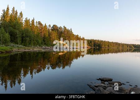 Goldenes Abendlicht und Waldspiegelungen auf dem Totaksee in Rauland, Norwegen Stockfoto
