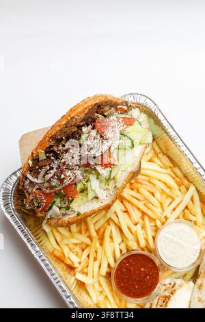Doner-Kapsalon-Sandwich in Pita-Brot mit Pommes und Soßen Stockfoto