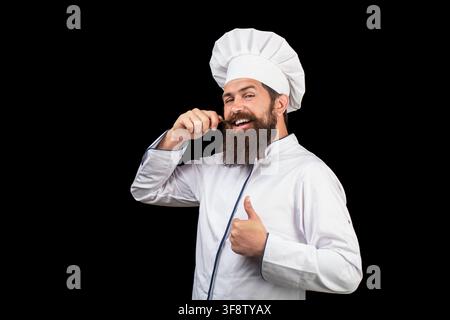 Lustige Koch mit Bart kochen. Bartmann und Schnurrbart tragen Lätzchen Schürze. Windeliger Mann. Portrait eines glücklichen Küchenchefs. Kochmütze. Bärtiger Koch, Köche oder Stockfoto