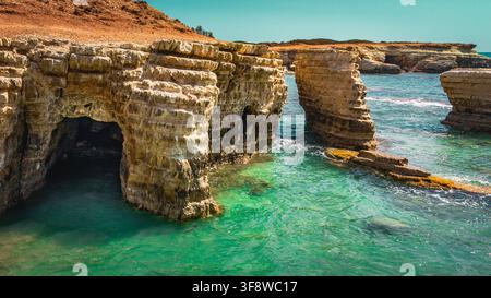 Wunderschöne natürliche Meeresgrotten und Felsbögen im klaren türkisfarbenen Wasser von Zypern. Stockfoto