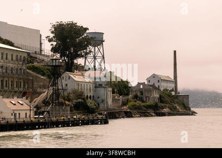 SAN FRANCISCO, VEREINIGTE STAATEN - 5. Juli 2026: Blick auf Alcatraz Island vom Wasser aus, der das Hauptzellenhaus, den Wasserturm, Industriegebäude und Stockfoto
