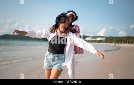 Reines Glück. Ein junges, vielseitiges, multiethnisches Paar genießt jeden Moment ihres tropischen Urlaubs Stockfoto