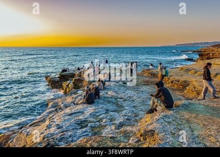 Menschen, die auf felsigen Klippen sitzen und den Sonnenuntergang über dem Meer beobachten. Sunset Cliffs, San Diego, Kalifornien, Vereinigte Staaten, Nordamerika Stockfoto